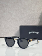 Navy round sunglasses with dark lenses and gold-tone accents on temples
