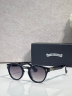 Black round sunglasses with dark lenses and metal temple accents