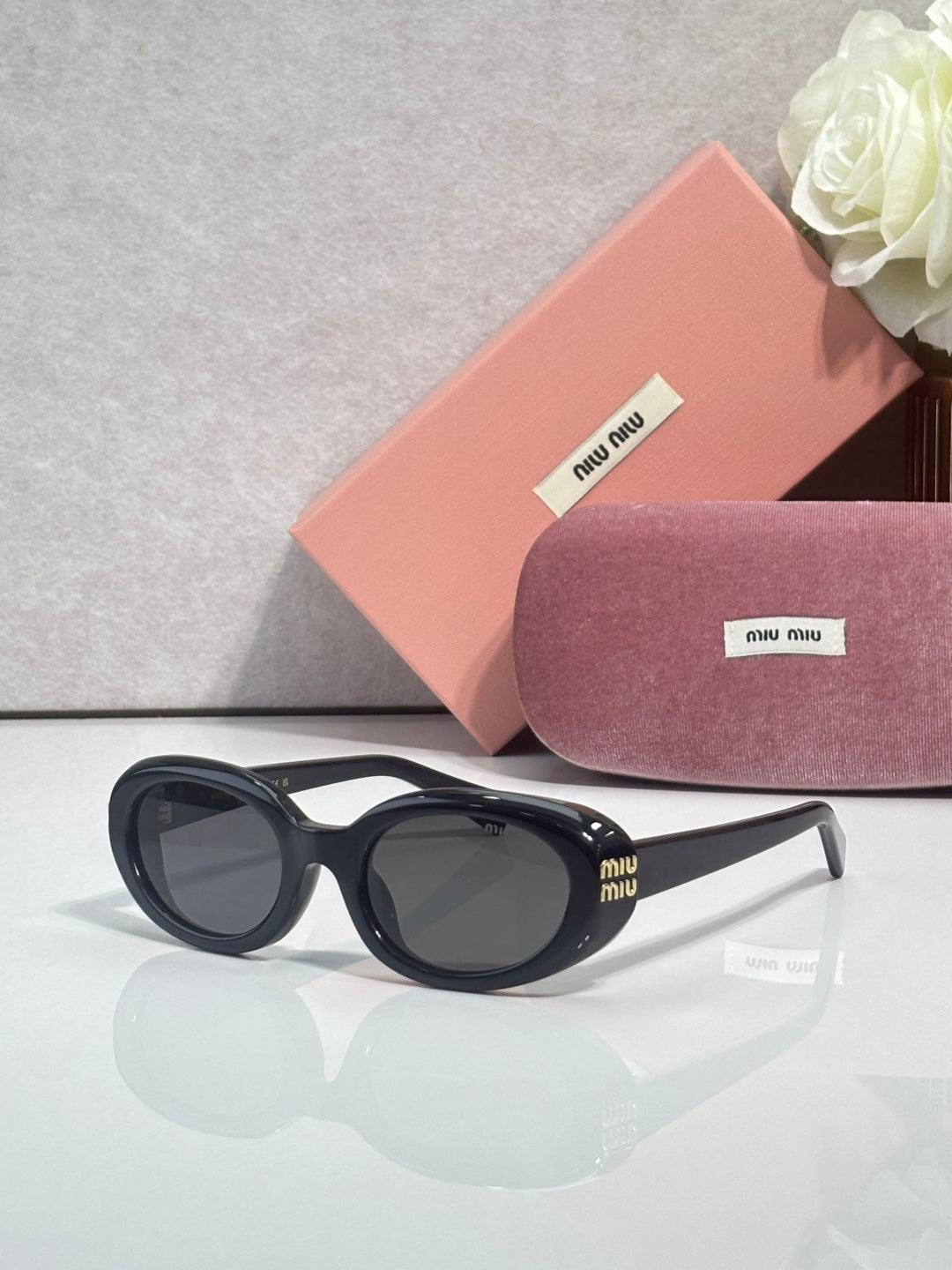 MiuMiu sunglasses with dark frame and gray tinted lenses
