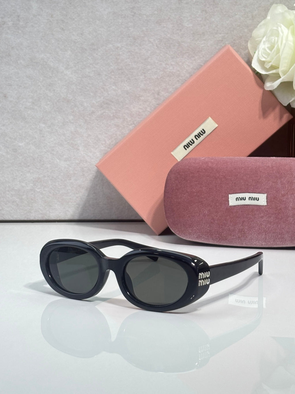 MiuMiu sunglasses with black frame and dark oval lenses