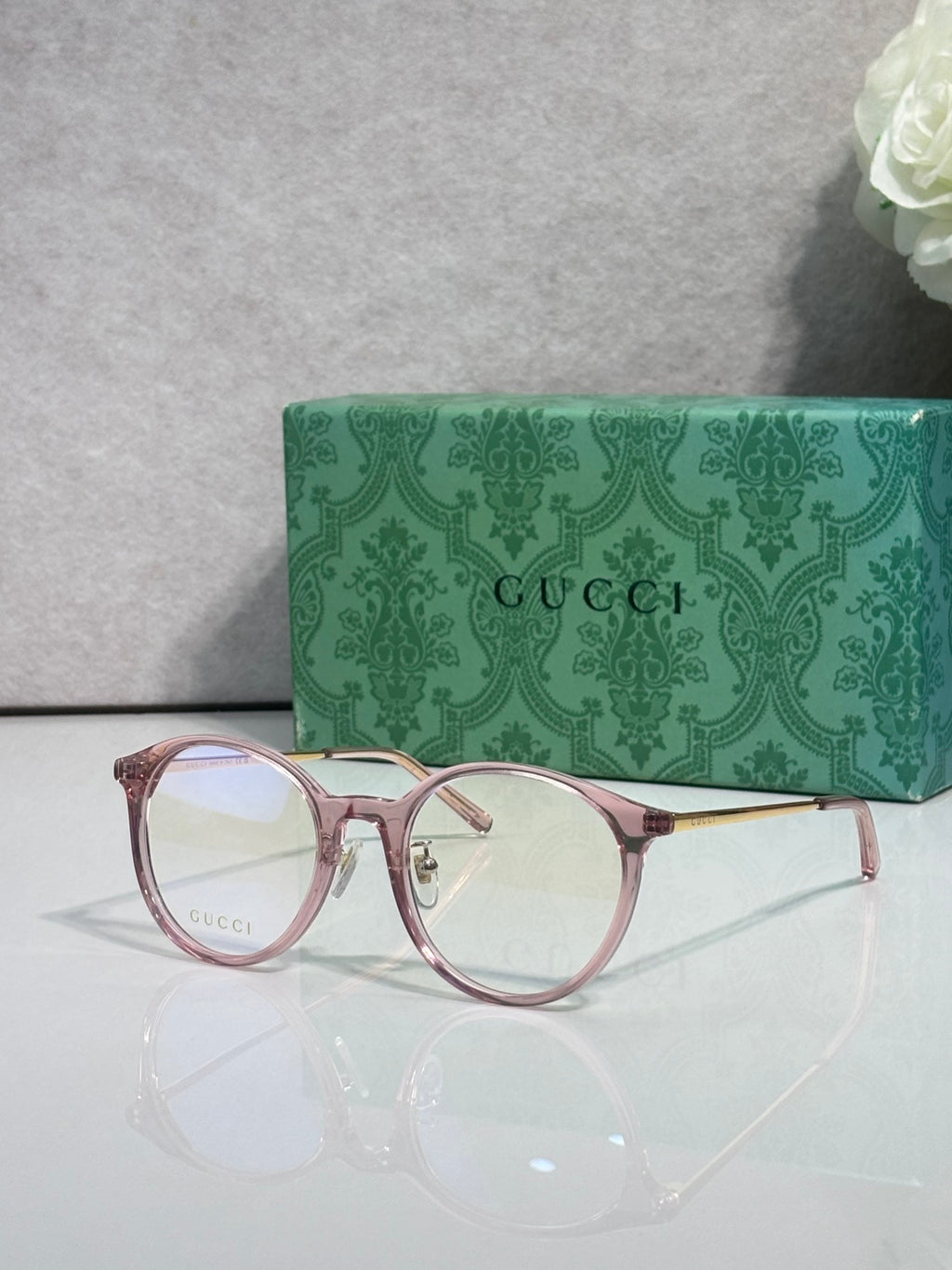 Gucci eyeglasses with clear lenses and pinkish red plastic frame