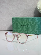 Gucci eyeglasses with clear lenses and pinkish red plastic frame