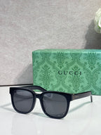 Gucci sunglasses with dark blue frame and wide oval smoky lenses