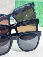 Gucci sunglasses with blue-tinted lenses and dark acetate frames