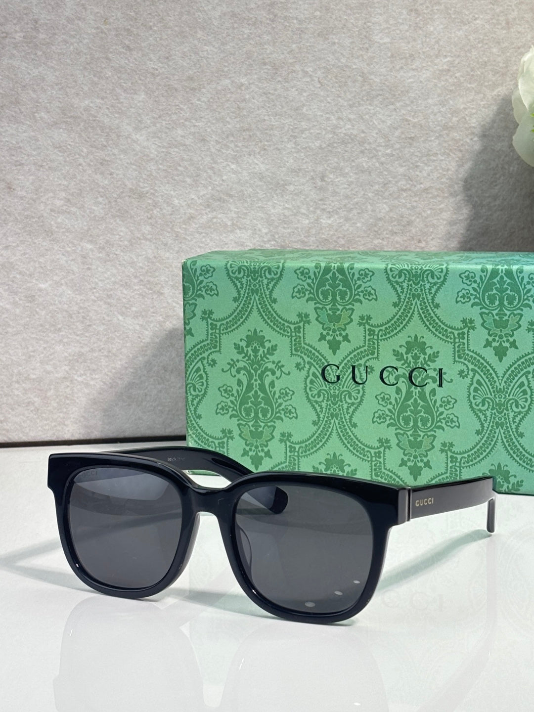 Gucci sunglasses with dark frame and large oval lenses, temple logo