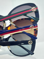 Gucci glasses side view with stacked striped temple arms (green, red, blue) and gold logo discs.