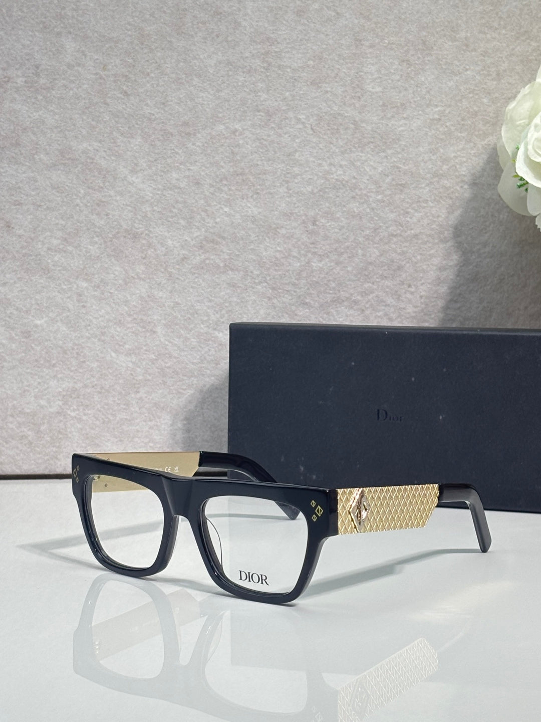 Dior eyeglasses with black square frames and gold textured temple detail