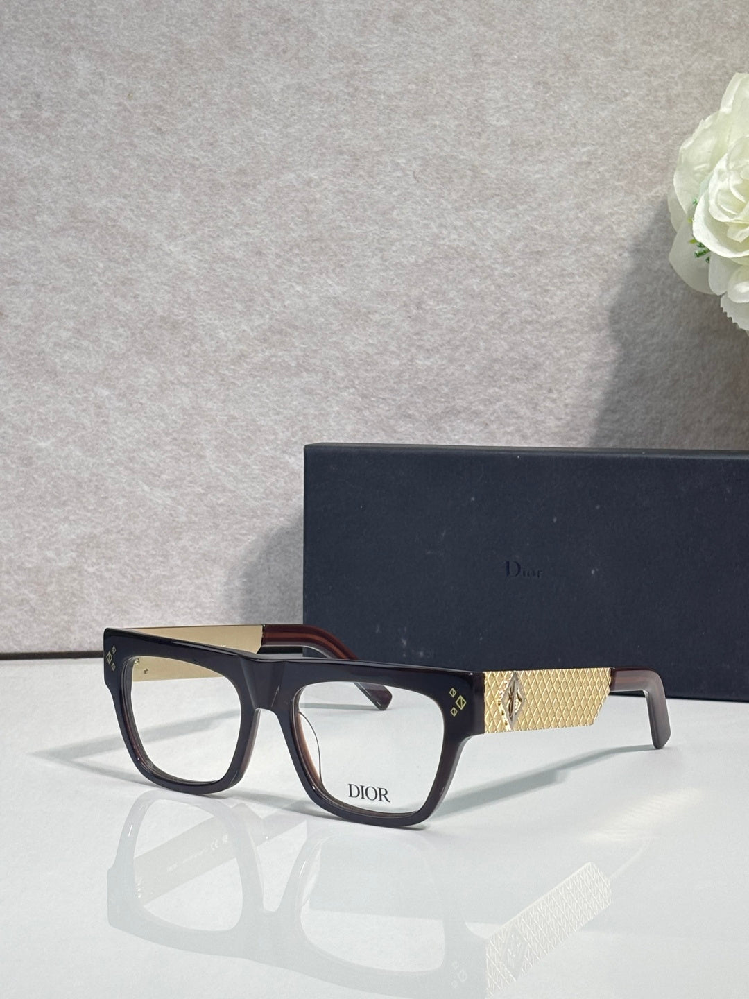 Dior eyeglasses with dark square frames and gold textured temple detail