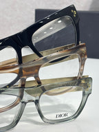 Dior eyeglasses close-up: stacked frames with gold temple and “Dior” branding