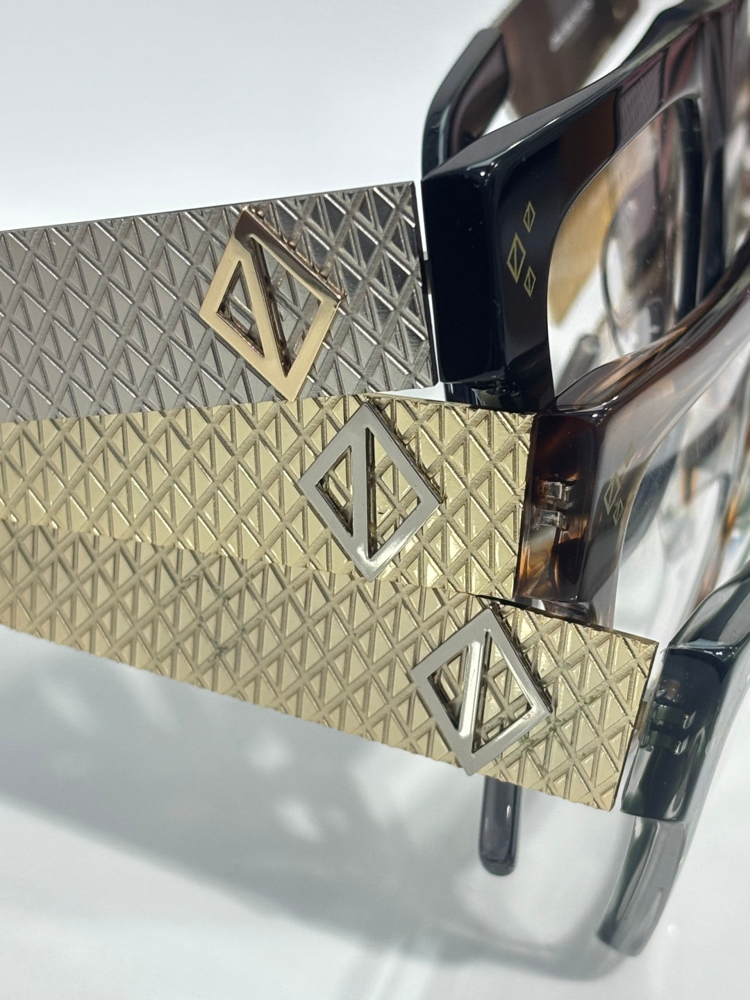 Dior eyeglasses close-up: gold textured temples with logo cutout