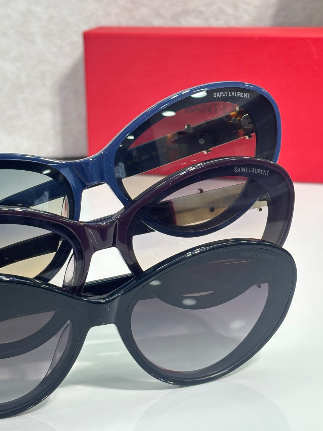 Blue cat-eye eyeglasses with gold logo temple emblem detail
