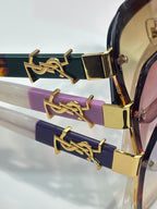 YSL glasses close-up: gold YSL logo hinge on purple and navy temples