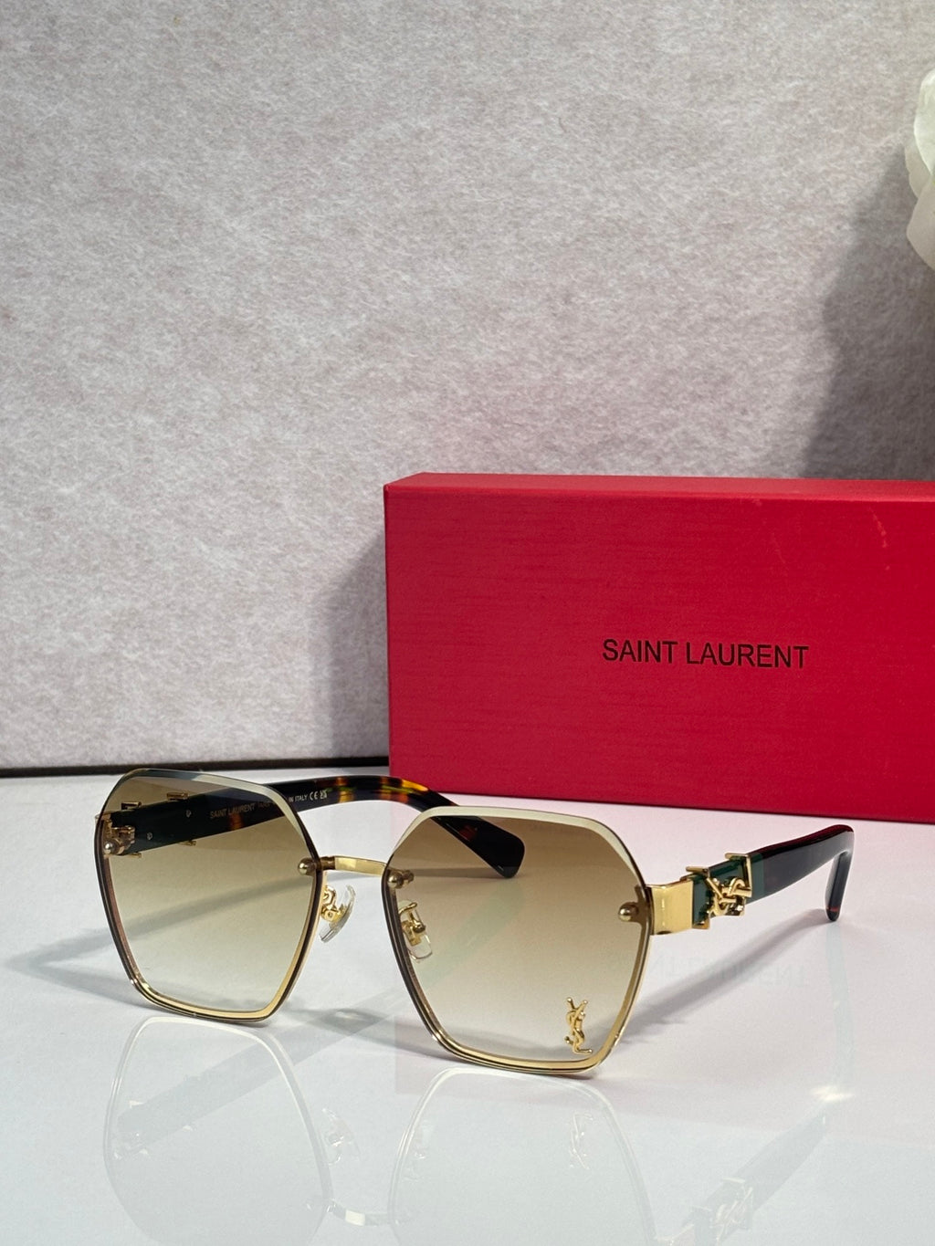 YSL glasses with gold frame and pale yellow tinted lenses, cat-eye silhouette
