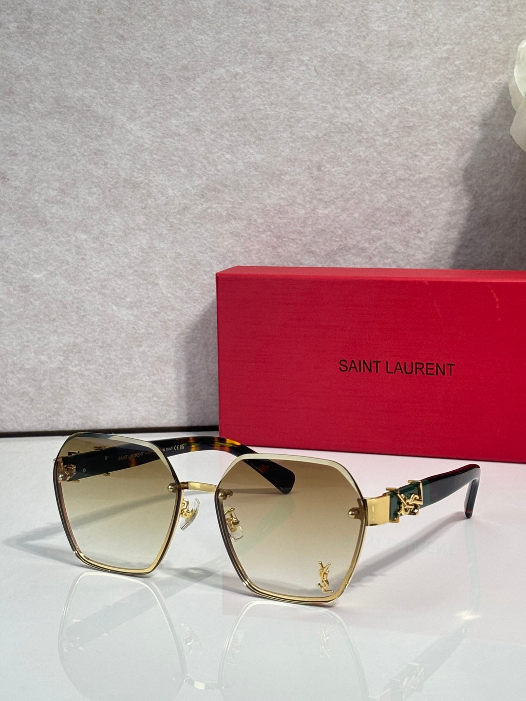 YSL glasses with gold frame and pale yellow tinted lenses, cat-eye silhouette