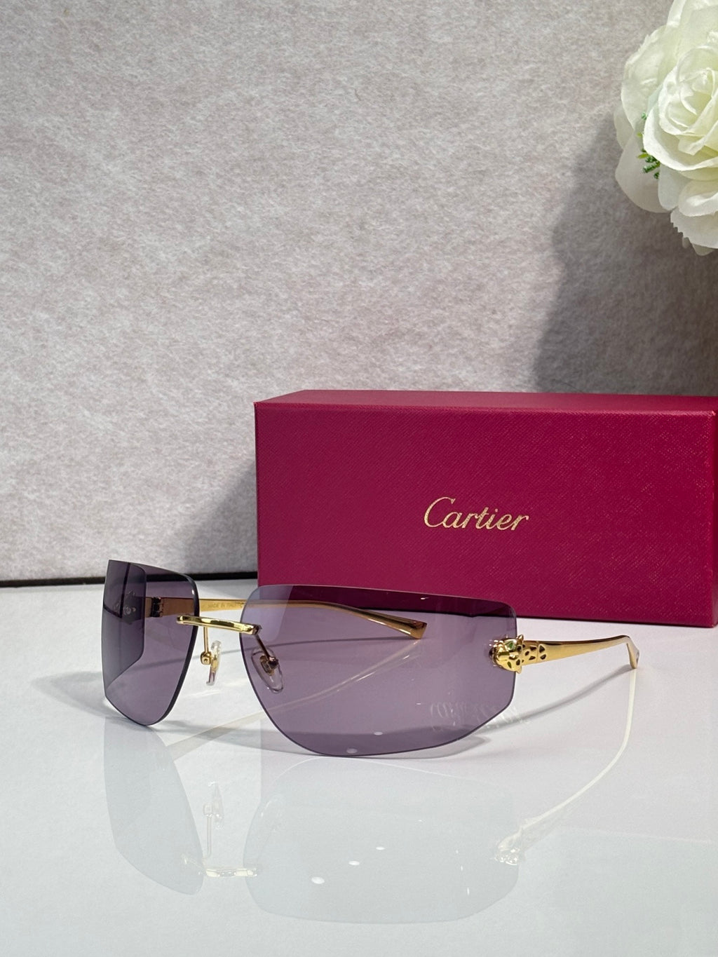 Cartier sunglasses with dark purple gradient lenses and gold-tone metal frame