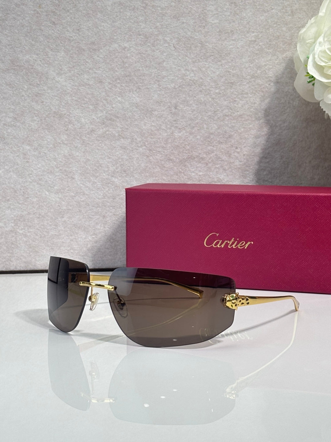 Cartier sunglasses with dark lenses and gold-tone metal frame, side profile