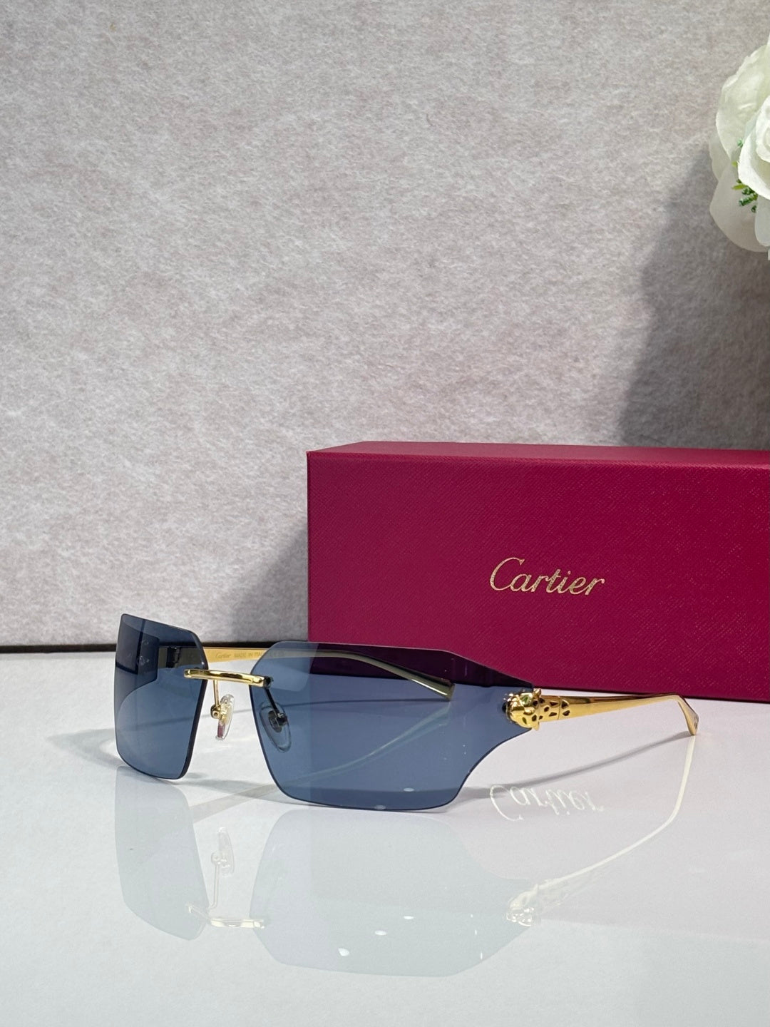 Cartier sunglasses close-up of gold hinge hardware and dark blue lens