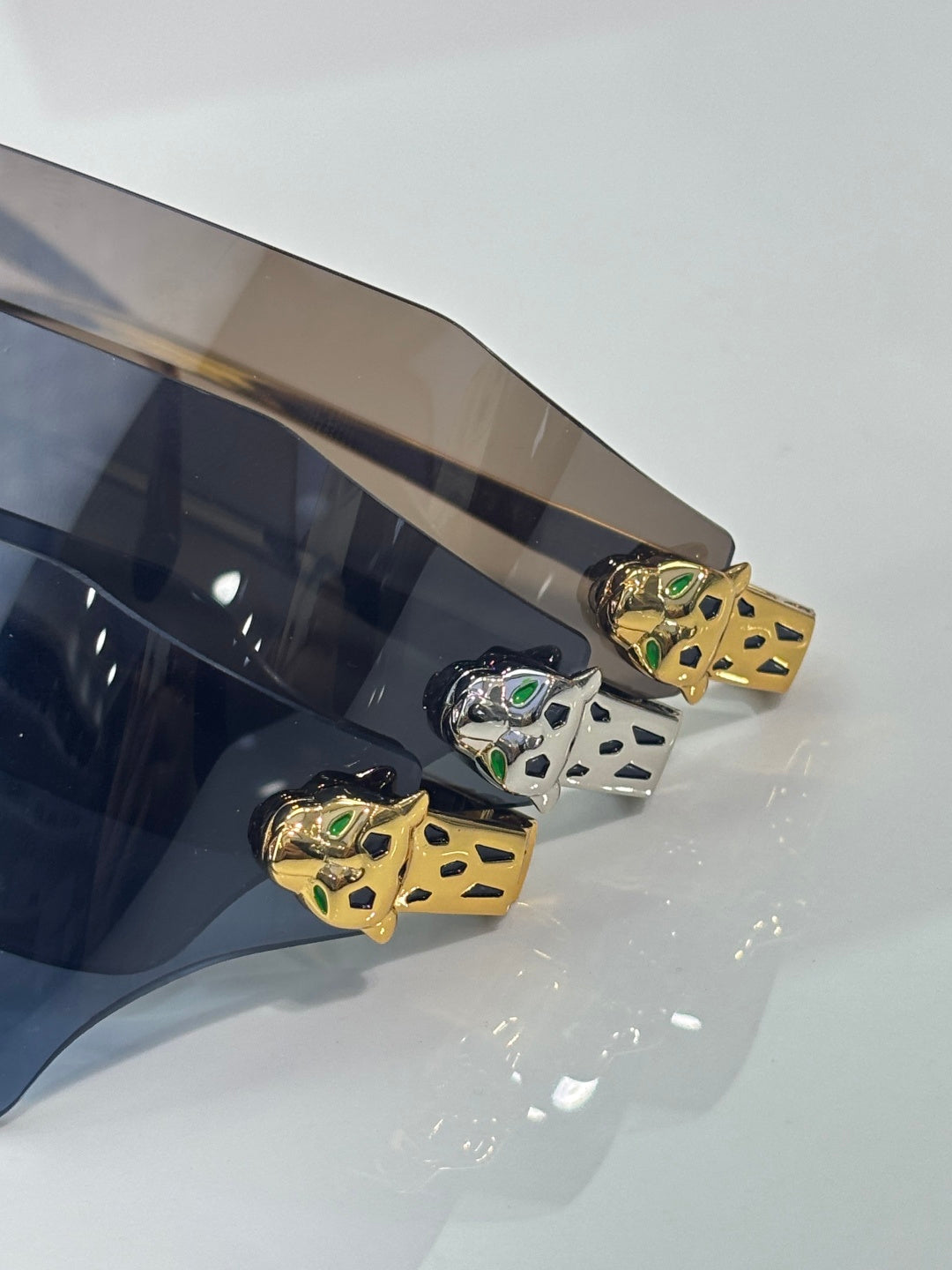 Cartier sunglasses close-up of gold temple detail with small green accents