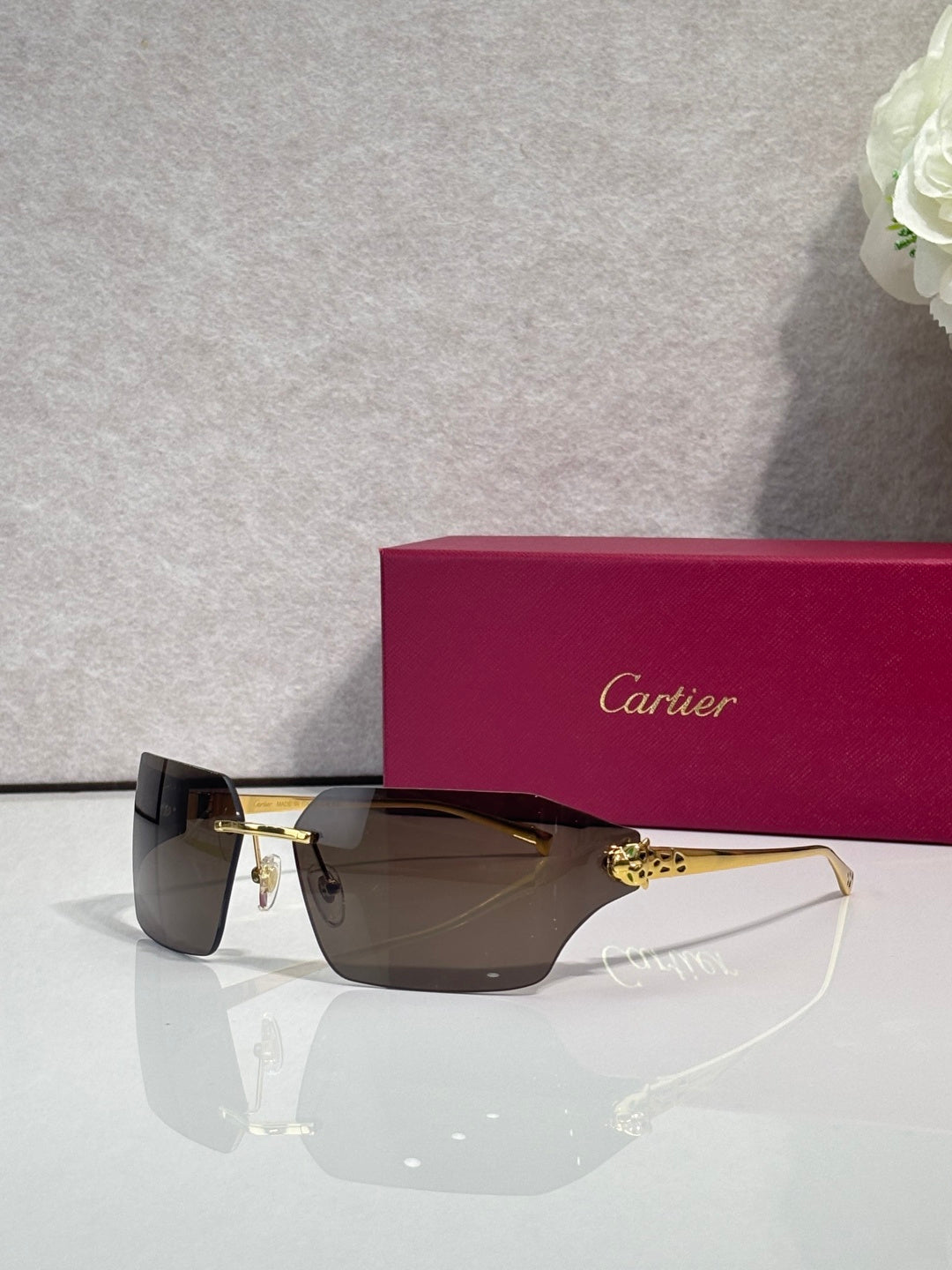 Cartier square sunglasses with dark lenses and gold-tone hinges, angled