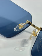 Cartier sunglasses close-up with dark blue lenses and gold metal bridge