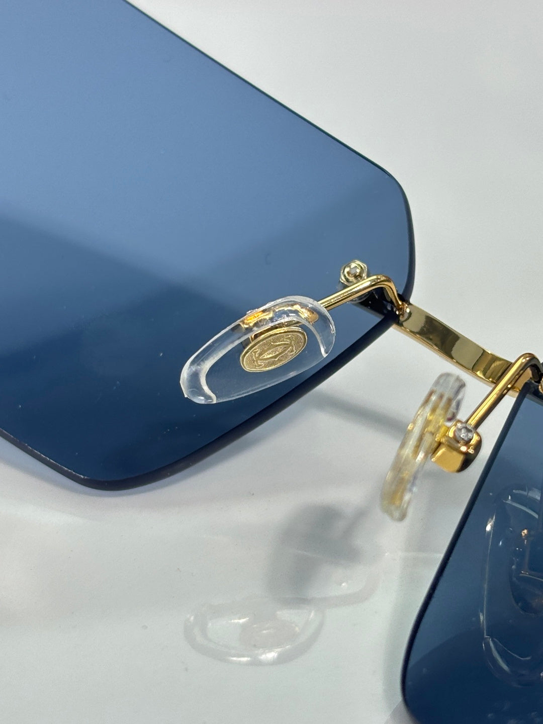 Cartier sunglasses close-up with dark blue lenses and gold metal bridge
