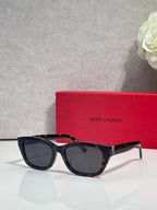 Black and tortoise acetate eyeglasses with dark lenses and gold-tone hinges