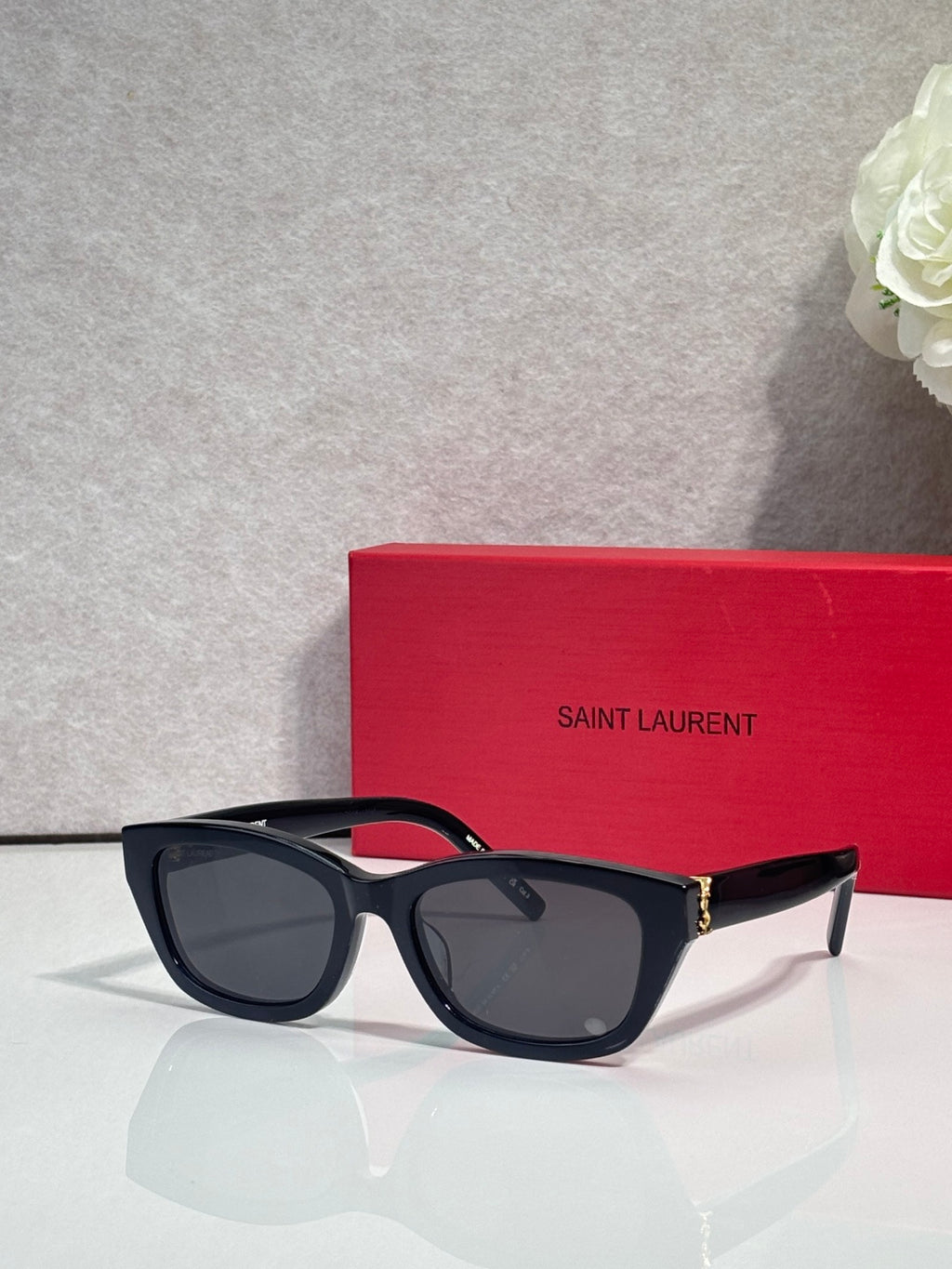 Black and tortoise cat-eye eyeglasses with dark lenses and gold-tone hinges