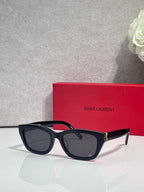Black and tortoise cat-eye eyeglasses with dark lenses and gold-tone hinges