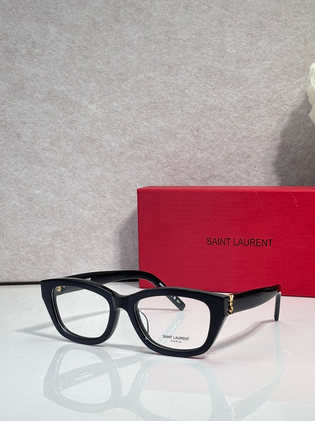 Black and tortoise eyeglasses with clear lenses, sculpted frame, and gold-tone hinges