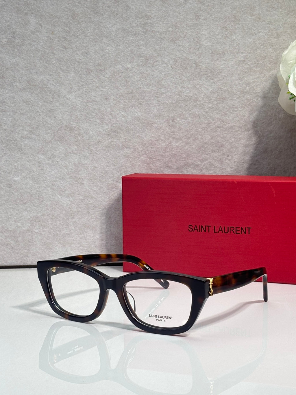 Black and tortoise eyeglasses with clear lenses and gold-tone hinges