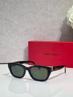 Black and tortoise eyeglasses with green-tinted lenses and gold-tone hinges