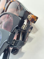 Chanel glasses close-up with glossy black frames and metal hinge details