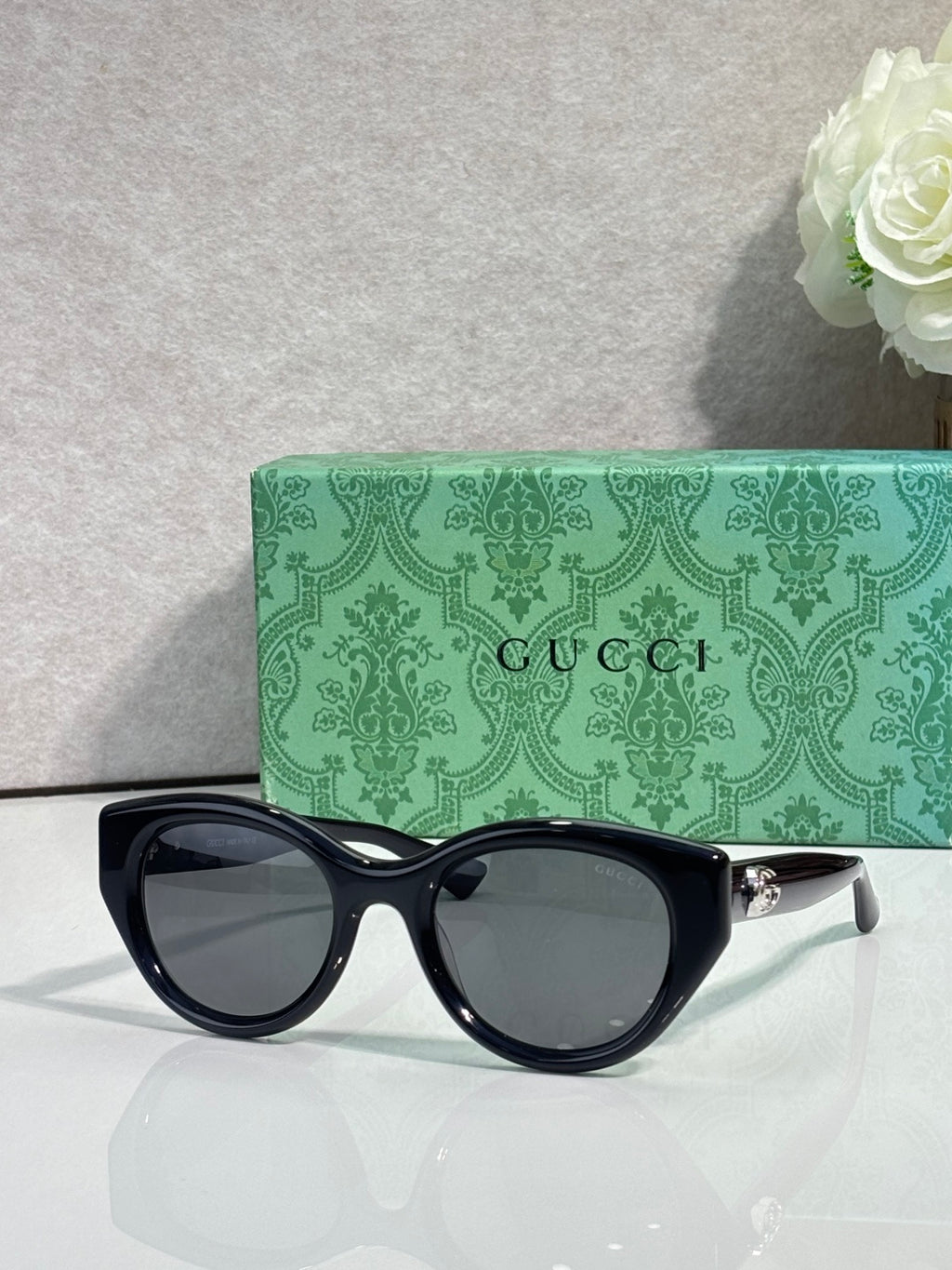 Gucci cat-eye sunglasses, black frame with dark lenses.
