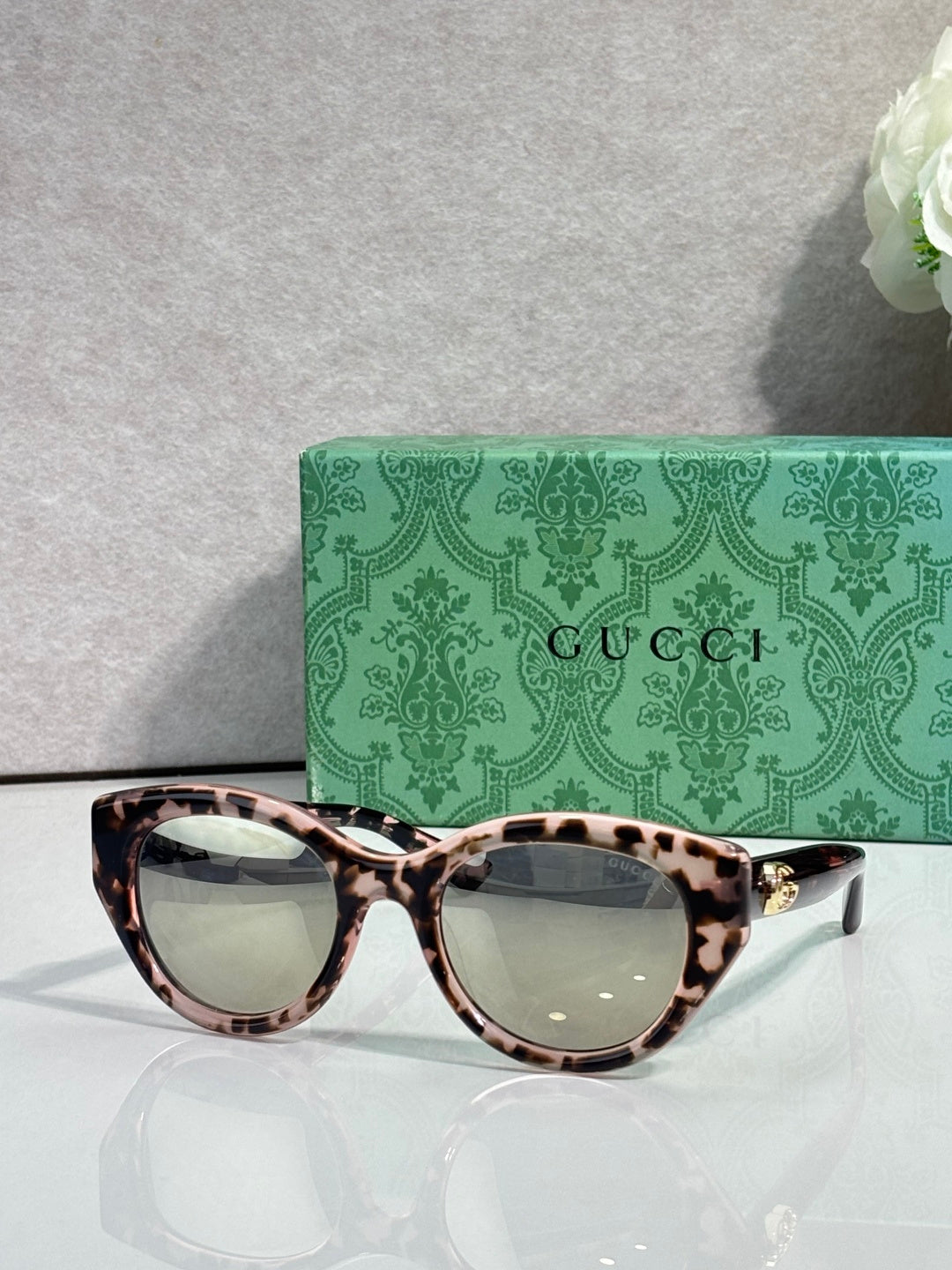 Gucci cat-eye sunglasses, tortoiseshell frame with dark lenses.
