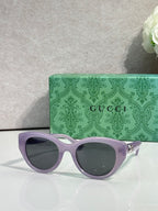 Gucci cat-eye sunglasses, light purple frame with dark lenses.