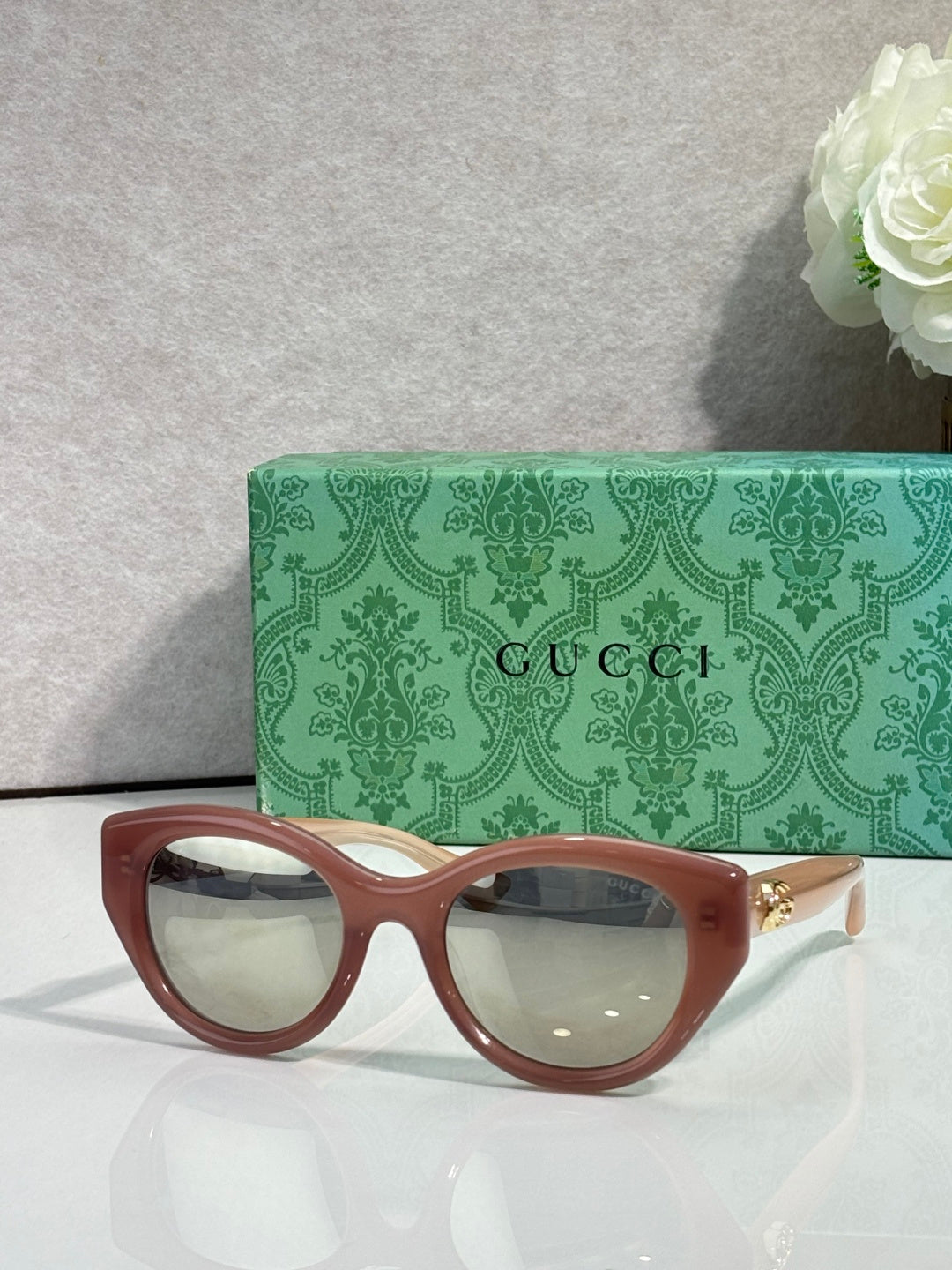 Gucci cat-eye glasses, brown frame with light lenses.