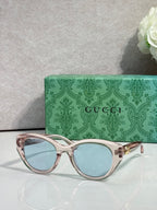 Gucci cat-eye glasses, rose-gold frame with light blue lenses.