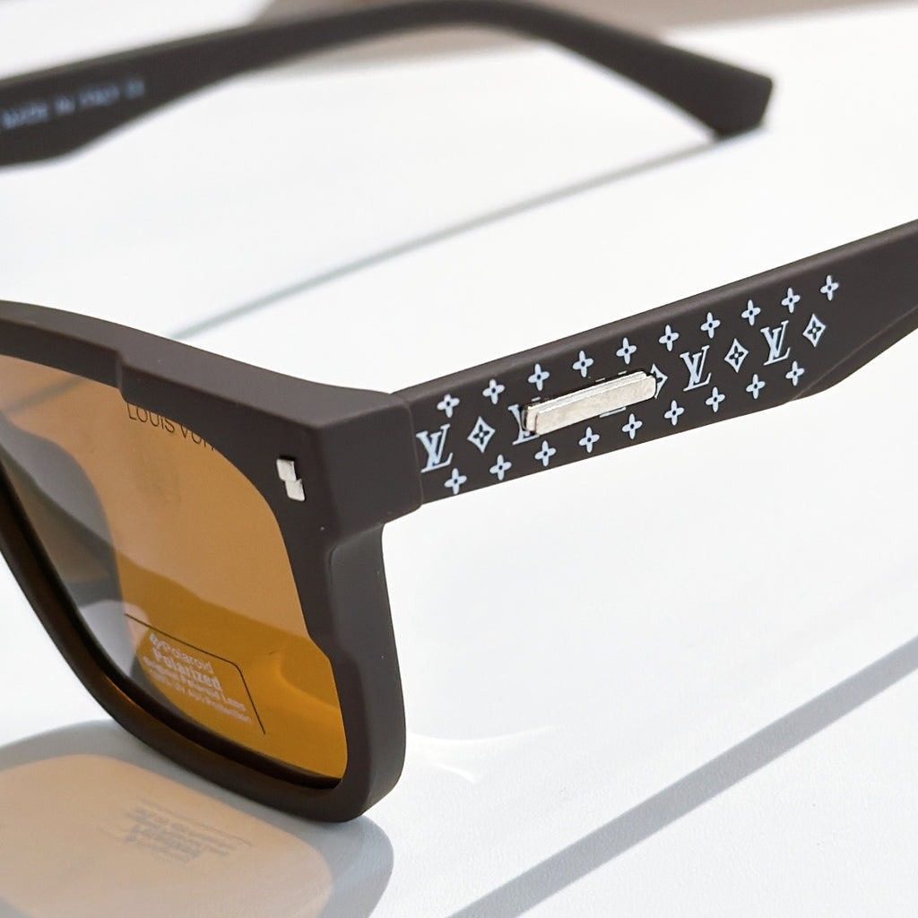 Louis Vuitton sunglasses close-up: black frames with patterned temple band and logo detail.