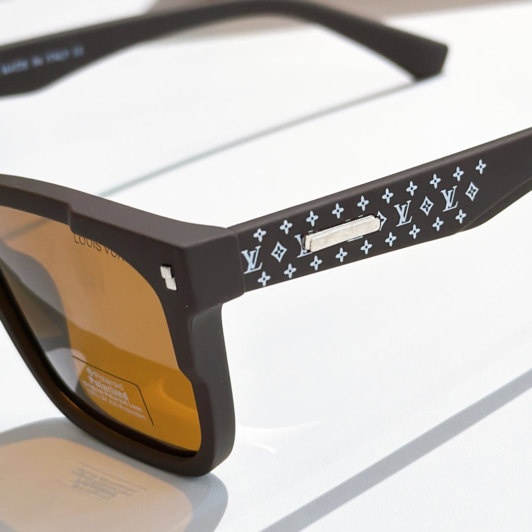 Louis Vuitton sunglasses close-up: black frames with patterned temple band and logo detail.