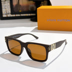 Louis Vuitton sunglasses with black frame, amber lenses, logo-pattern temple details.