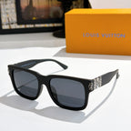 Louis Vuitton sunglasses with black frame and dark lenses; patterned temple inserts.