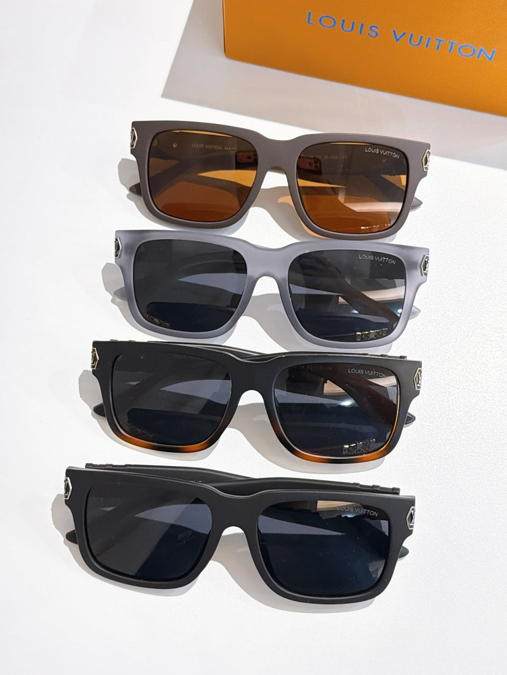Four pairs of Louis Vuitton sunglasses with patterned temple bands and mixed lens tints.
