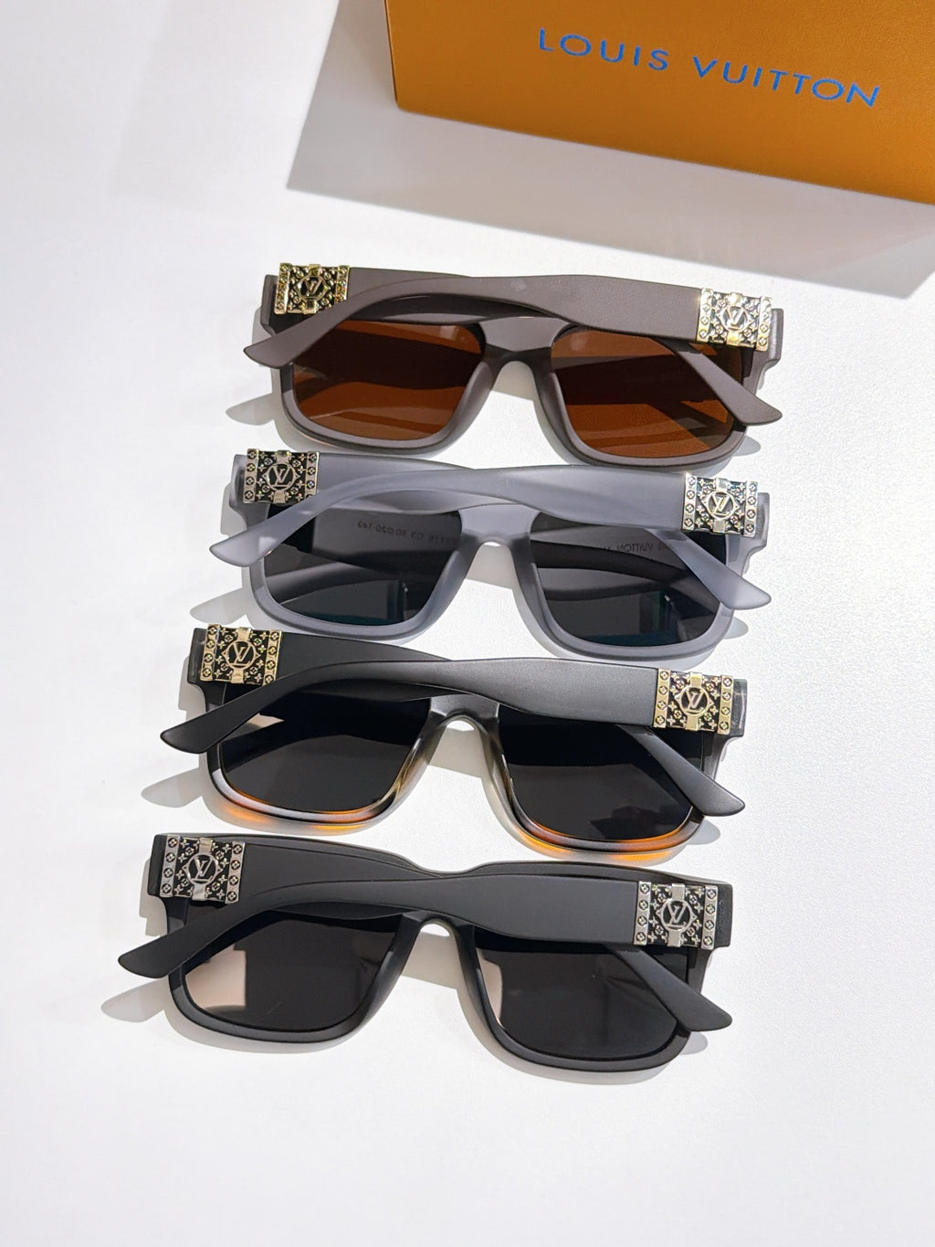 Set of Louis Vuitton sunglasses with mixed frames and patterned temple bands, stacked together.