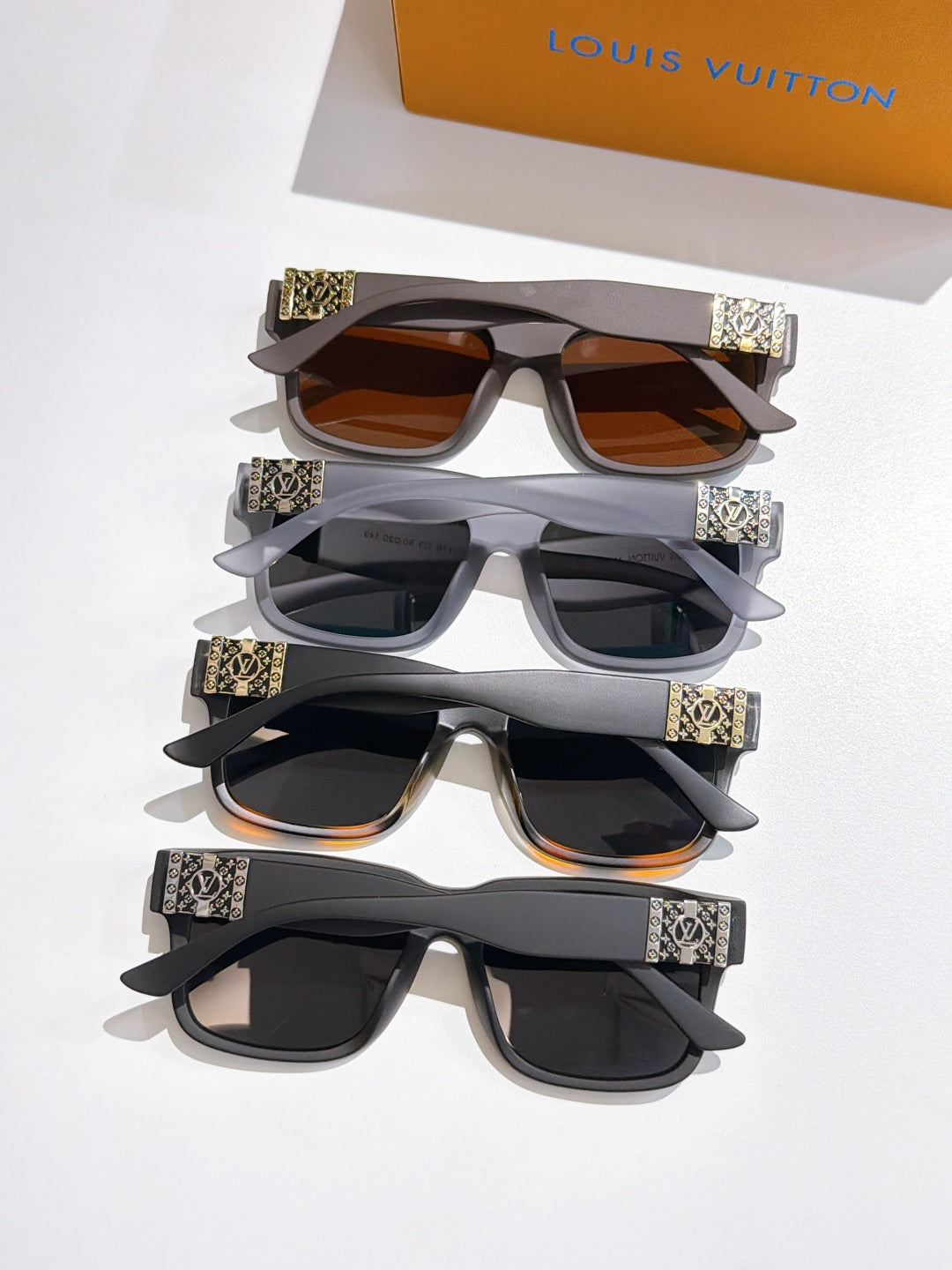 Set of Louis Vuitton sunglasses with mixed frames and patterned temple bands, stacked together.