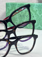 Eyeglasses frames stack with black and burgundy arms, clear lenses, GG accents