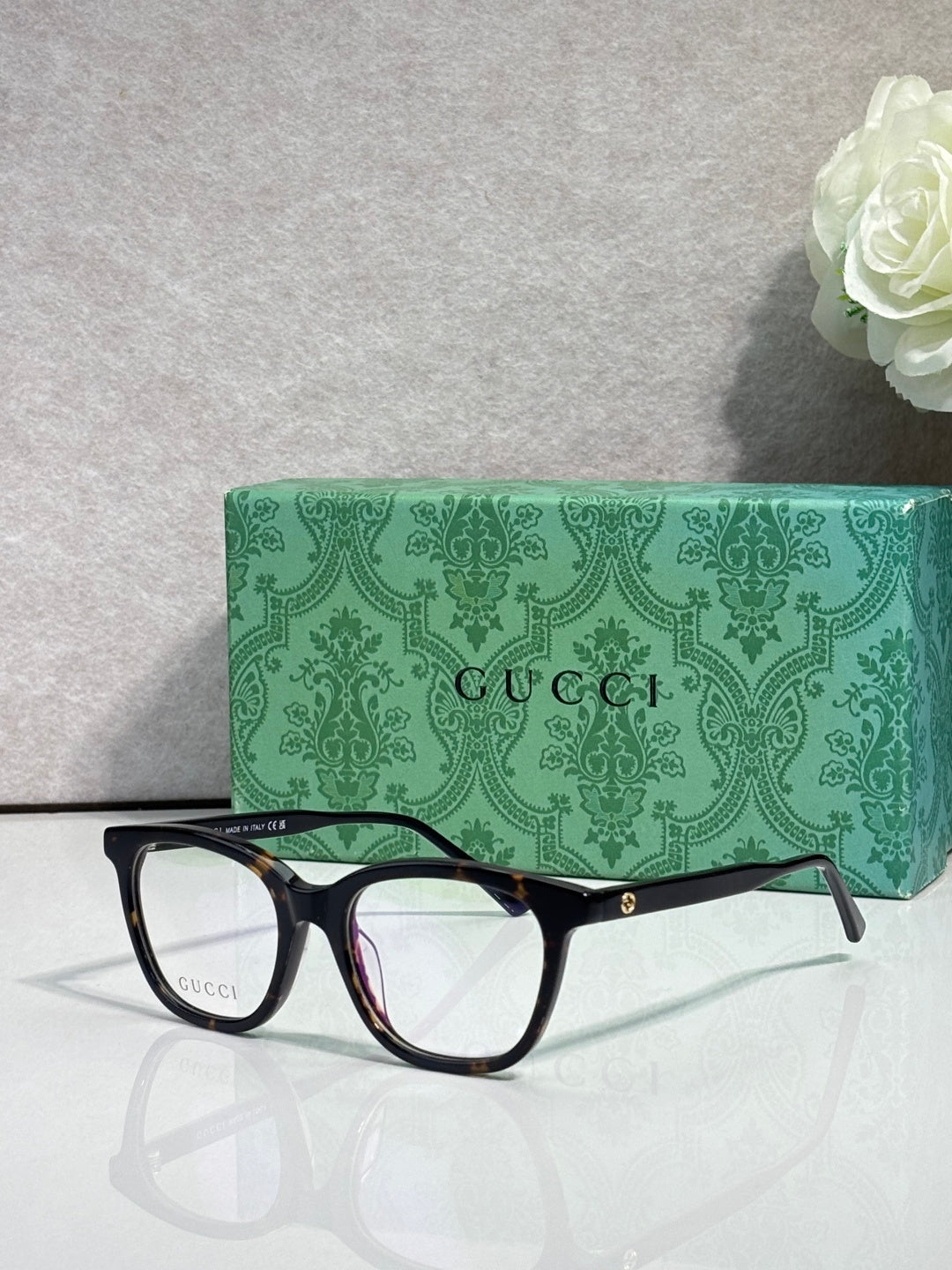 Gucci eyeglasses with black frames and clear lenses, burgundy accent near hinge