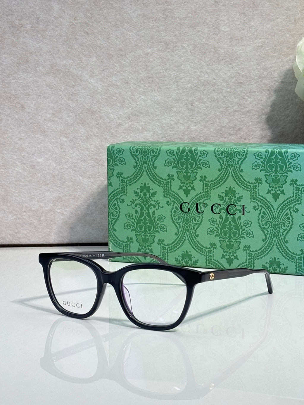 Gucci eyeglasses with dark frames, clear lenses, and slim burgundy side stripe