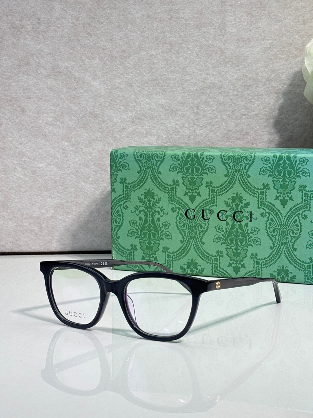 Gucci eyeglasses with dark frames, clear lenses, and slim burgundy side stripe