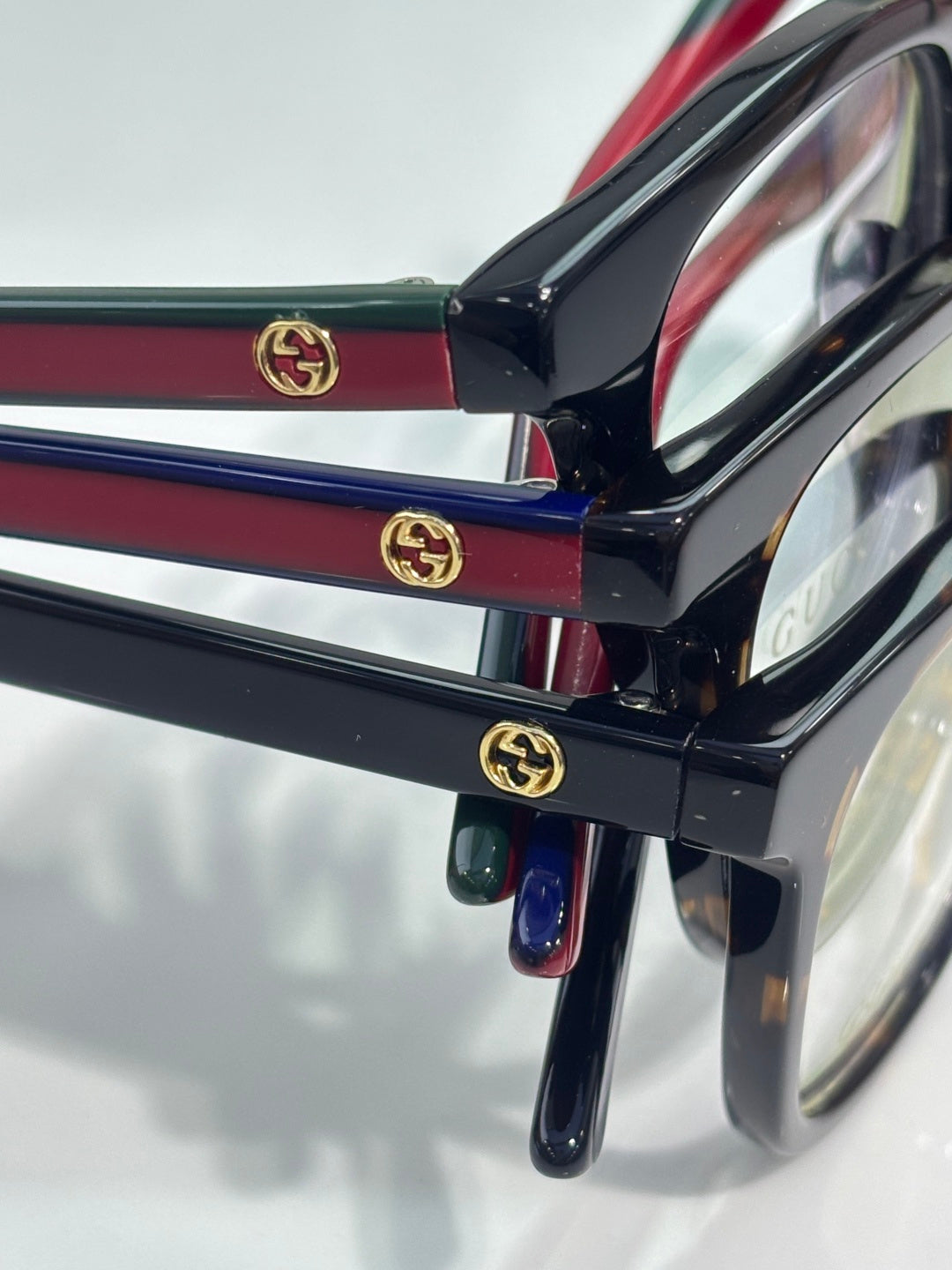 Black and burgundy eyeglasses with GG logo hinge detail and clear lens