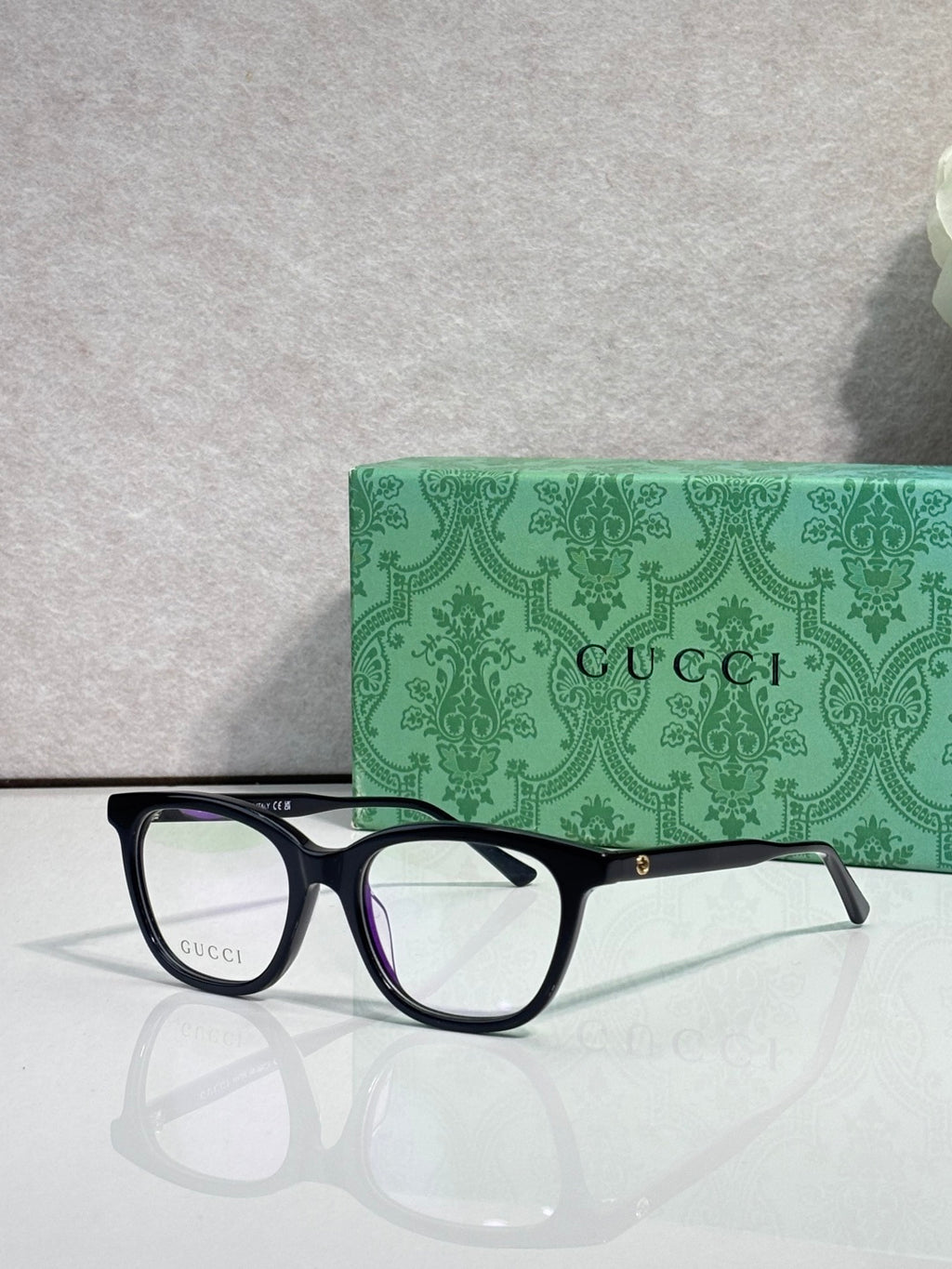 Gucci eyeglasses with black frames, clear lenses, and burgundy temple accents